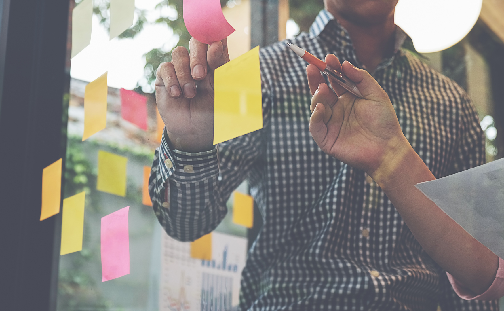 software development agency conducting a product validation and posting post-its on a window wall