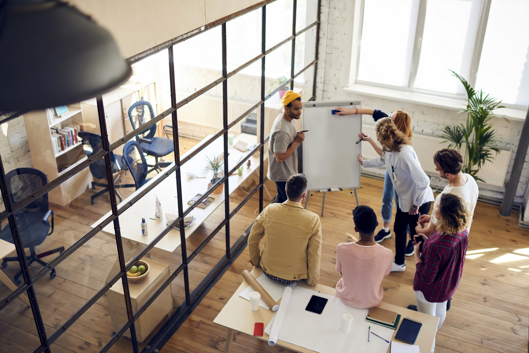 A product development team working on a whiteboard, defining product requirements and project specifications